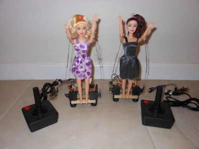 Blonde and Brunette dolls with circuit and Atari 2600 Joysticks ready to have a cat fight.